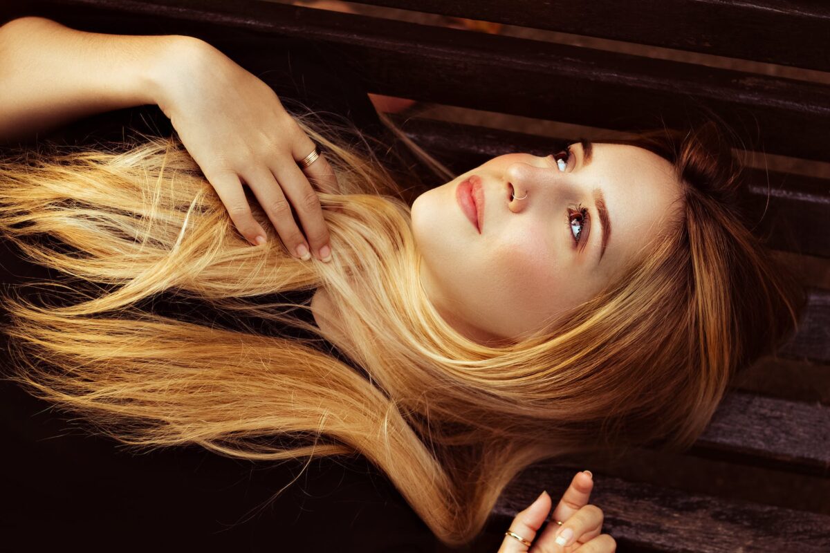 beautiful woman with blonde hair lying on wooden surface